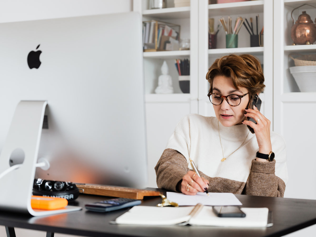 serious-lady-talking-on-smartphone-and-taking-notes-on-paper-4491477