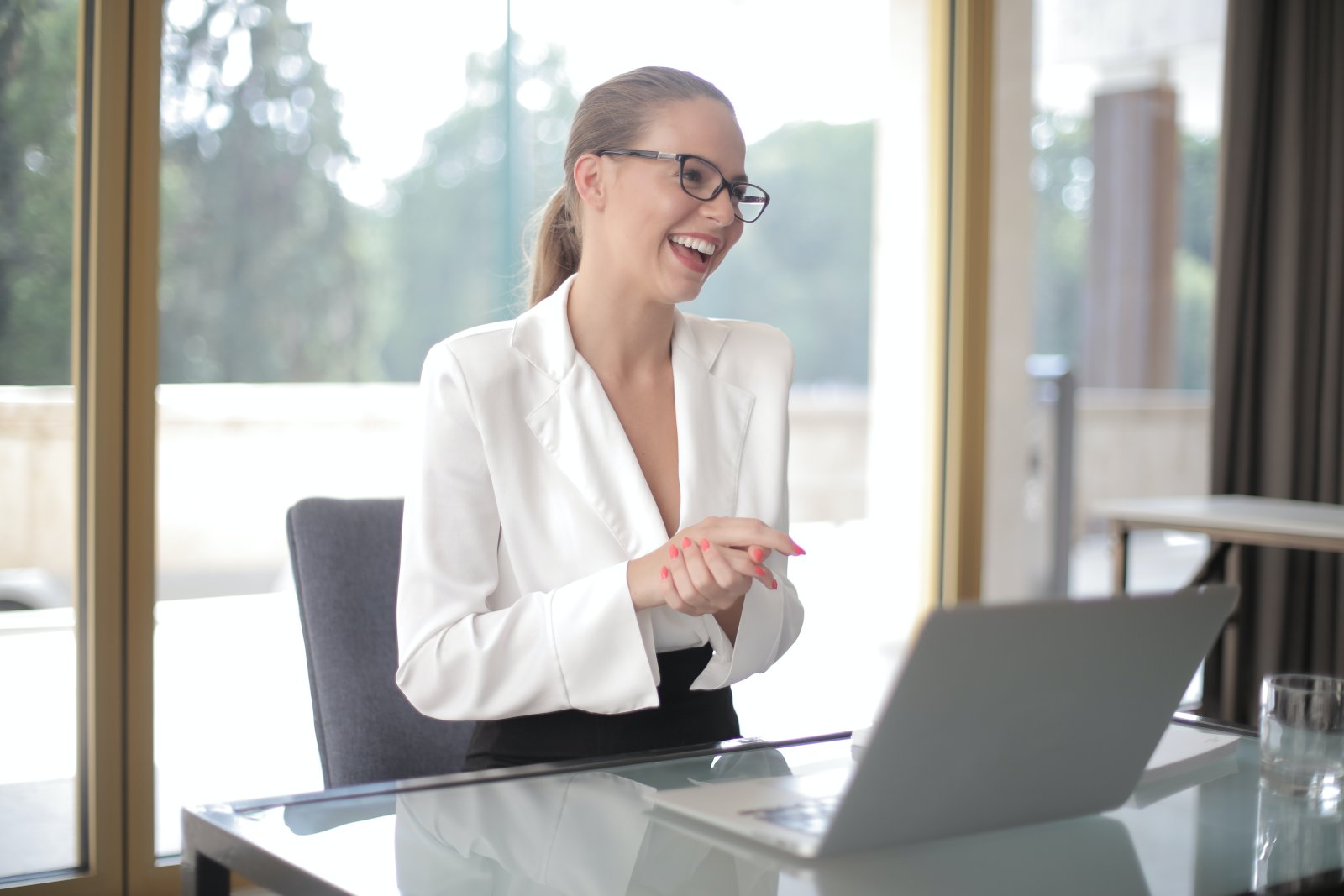 smiling-businesswoman-with-laptop-in-office-3855619